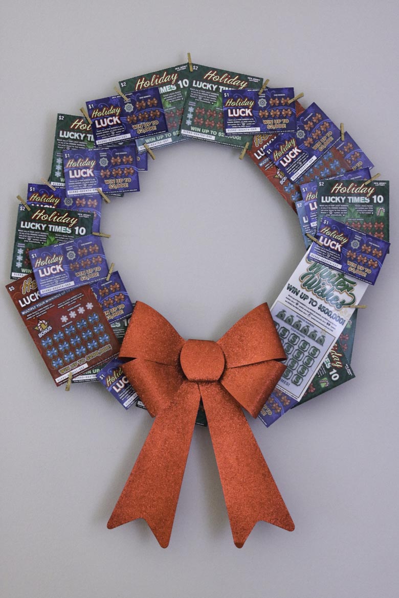 Lottery ticket wreath with a large red box hanging on a wall