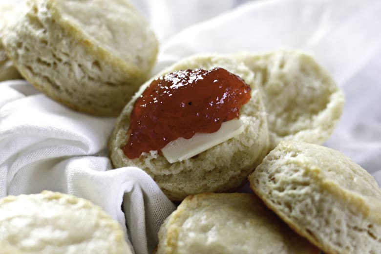 closeup of buttermilk biscuits with butter and jam