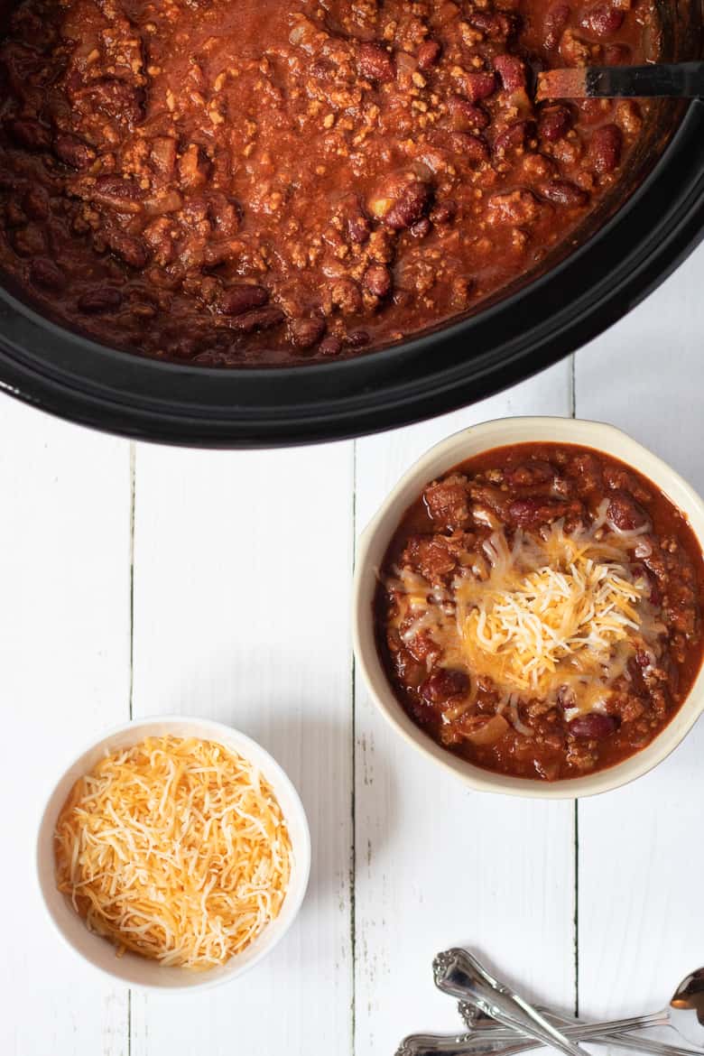 Bowl of chili topped with shredded cheese.