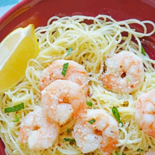 shrimp scampi over angel hair pasta served with a lemon wedge and topped with parsley