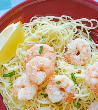 shrimp scampi over angel hair pasta served with a lemon wedge and topped with parsley