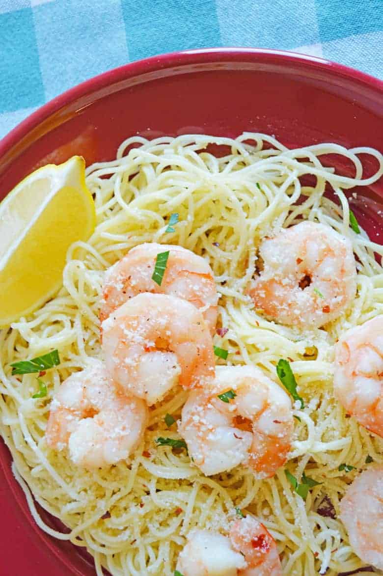 shrimp scampi over angel hair pasta served with a lemon wedge and topped with parsley