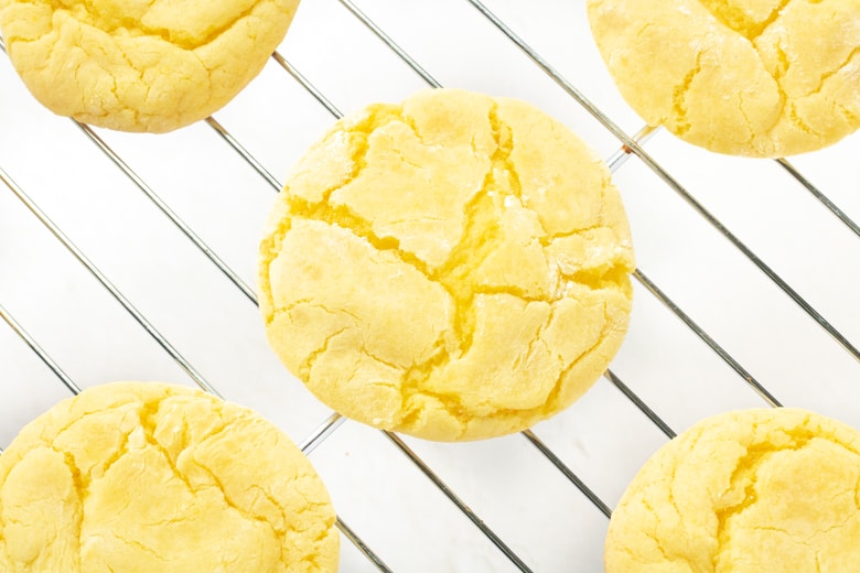 Easy Lemon Cookies with powdered sugar cooling on wire rack.