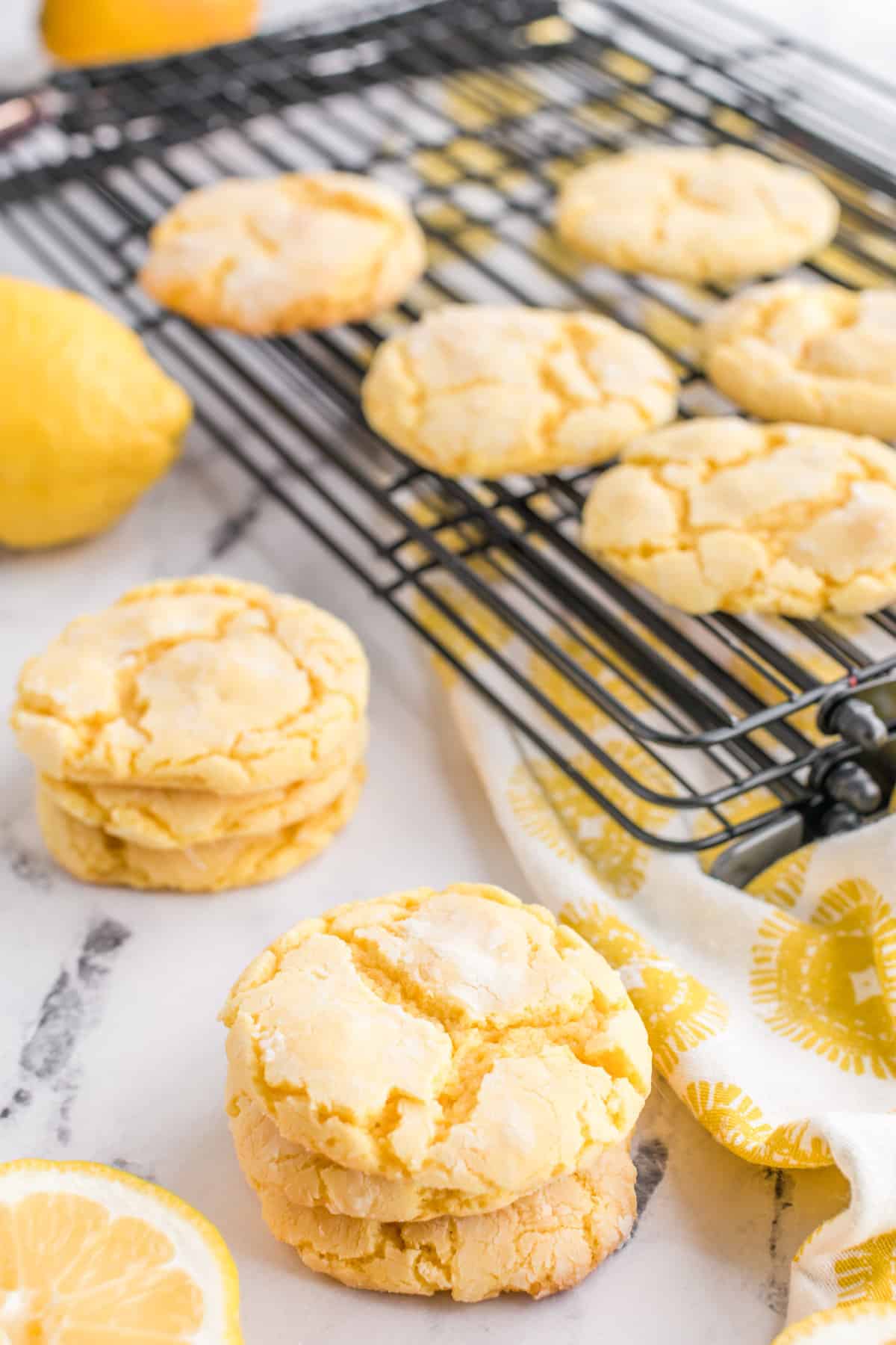 Lemon cookies made from cake mix next to a wire cooling rack with more cookies.