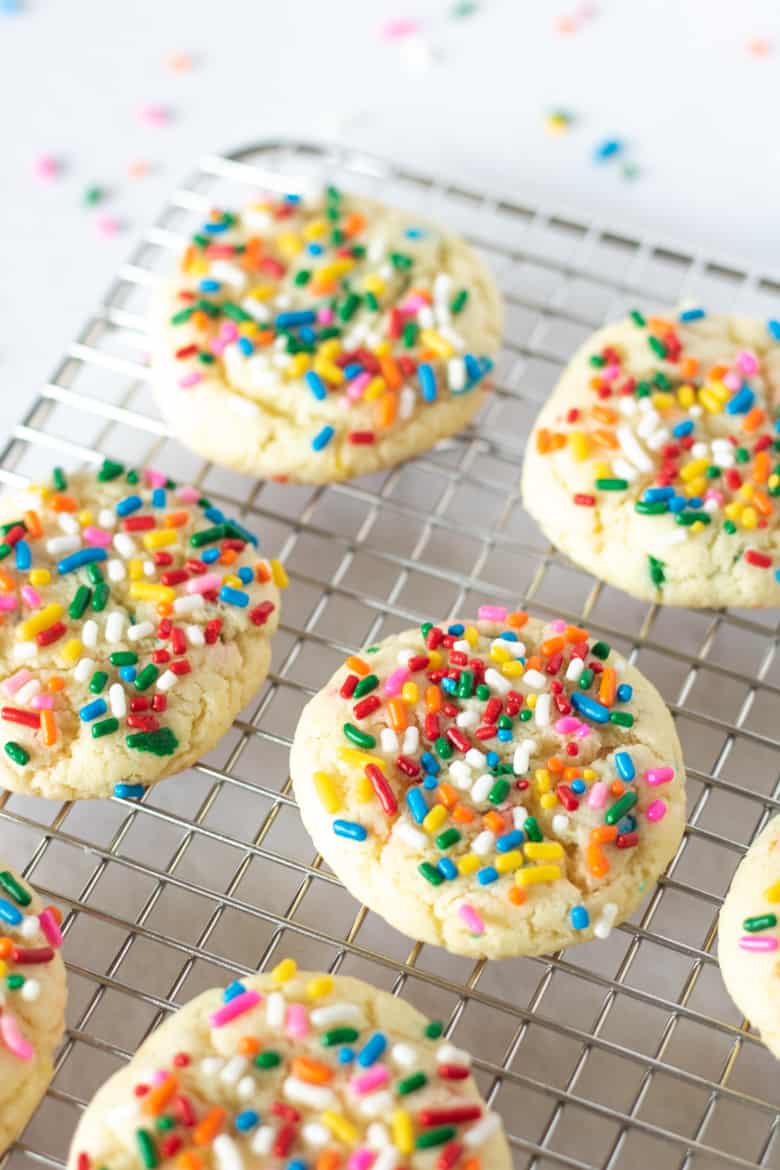 3 Ingredient Funfetti Cake Mix Cookies topped with rainbow sprinkles and sitting on a wire rack,