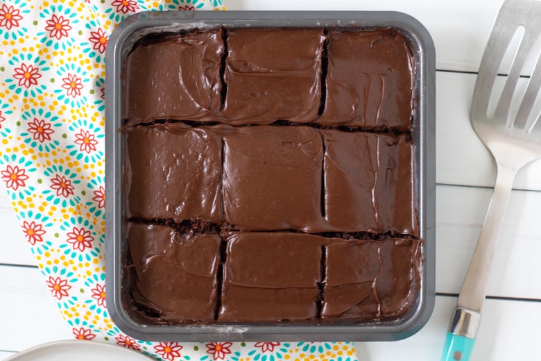 Crazy Chocolate Cake baked in a square pan and topped with chocolate frosting.