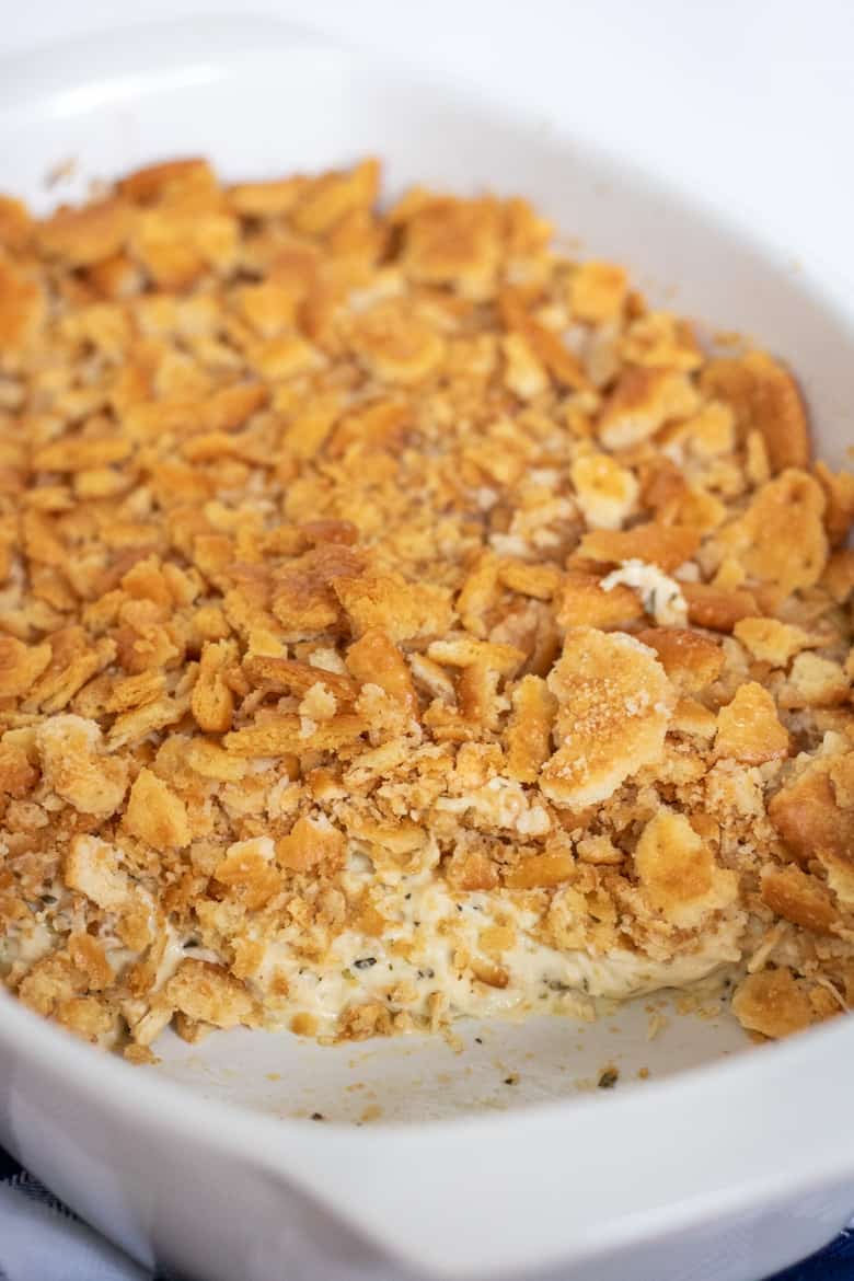 Ritz Chicken Casserole topped with crushed ritz crackers in white baking dish.