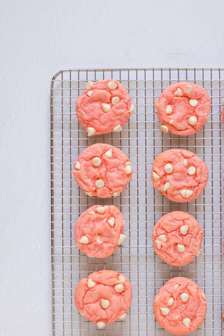 Strawberry Cake Mix Cookies with White Chocolate Chips on wire rack.