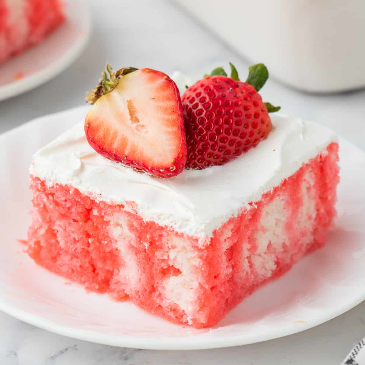 Strawberry jello poke cake with cool whip and fresh berries.