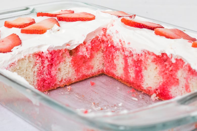 Vanilla cake with red jello poked throughout and topped with cool whip and fresh strawberries.