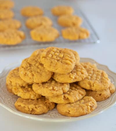 Cheese Cookies on a white plate with cookie on cooling rack in background