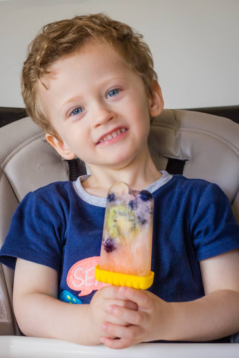Young boy eating fruit popsicle