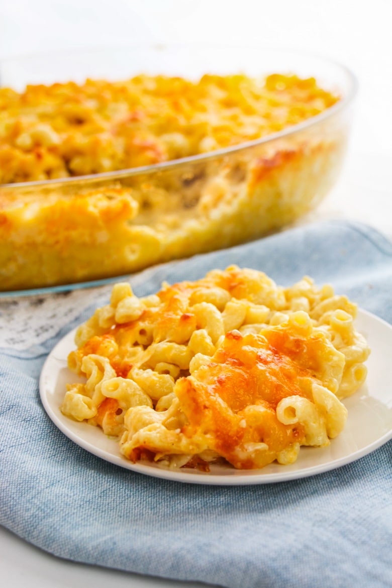 Elbow pasta with cheese on plate with casserole dish in backgronud