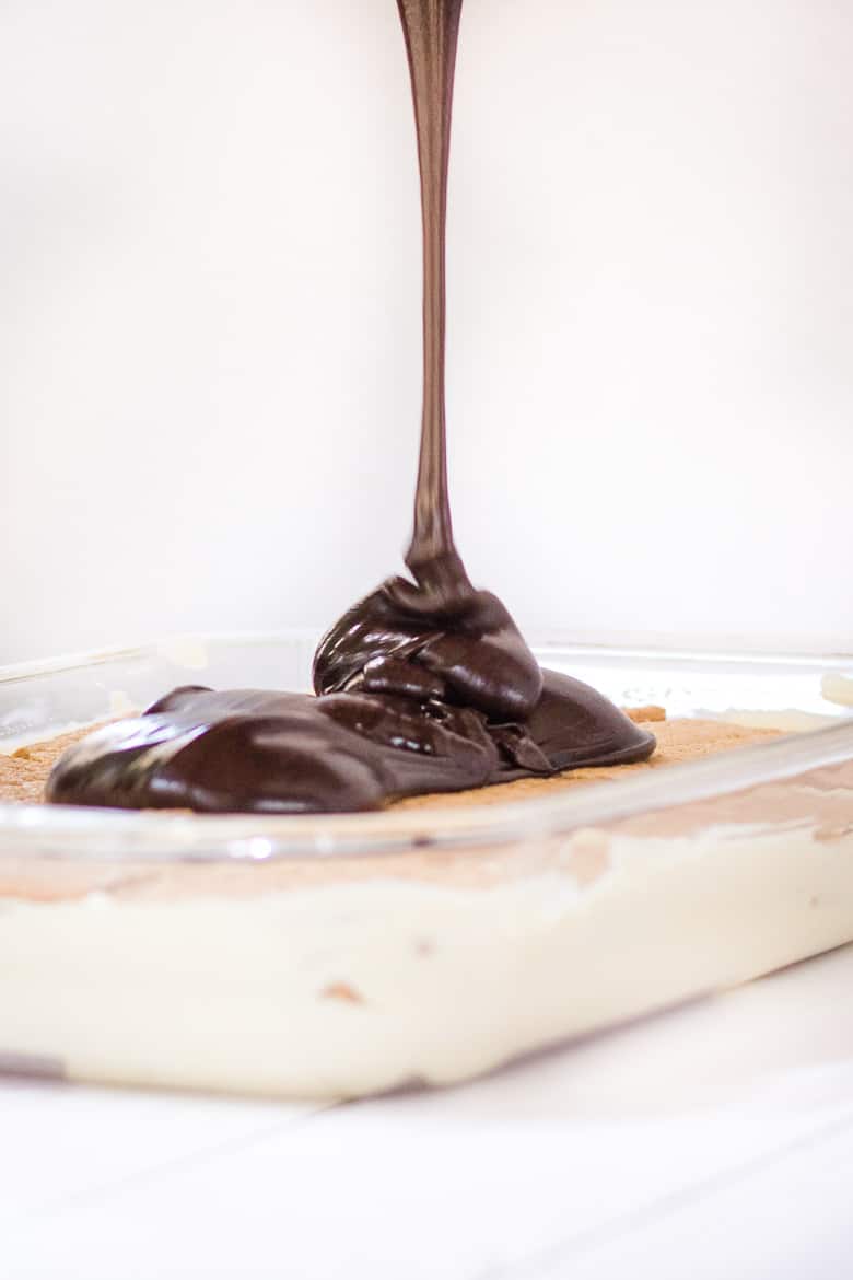 Pouring dark chocolate icing over cake