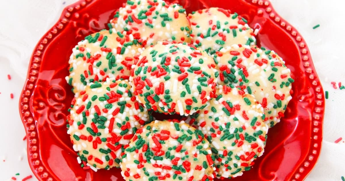 cookies covered in Christmas sprinkles on a red plate