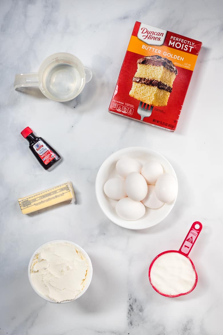 Ingredients for ricotta cake using boxed cake mix: Dunan Hines Perfectly Moist Butter Golden Cake Mix, 7 eggs, butter, vanilla, ricotta, and granulated sugar.