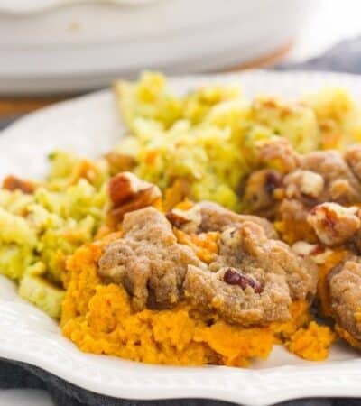 Pecan Streusel Sweet Potato Casserole on white plate with stuffing