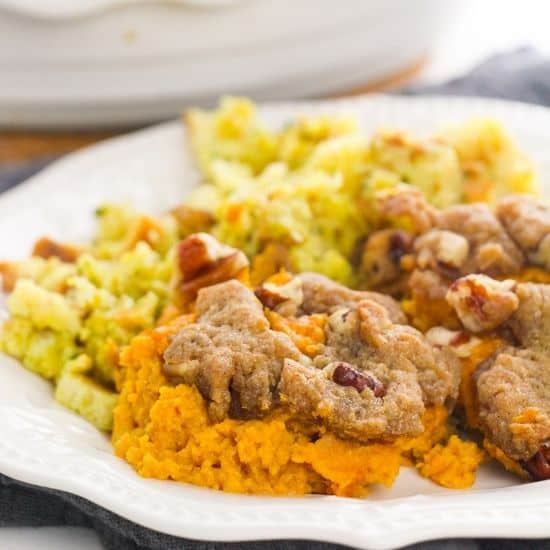 Pecan Streusel Sweet Potato Casserole on white plate with stuffing