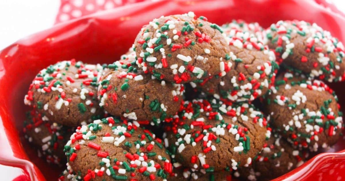 round gingerbread cookies with Christmas sprinkles, arranged in a red dish and on a red napkin