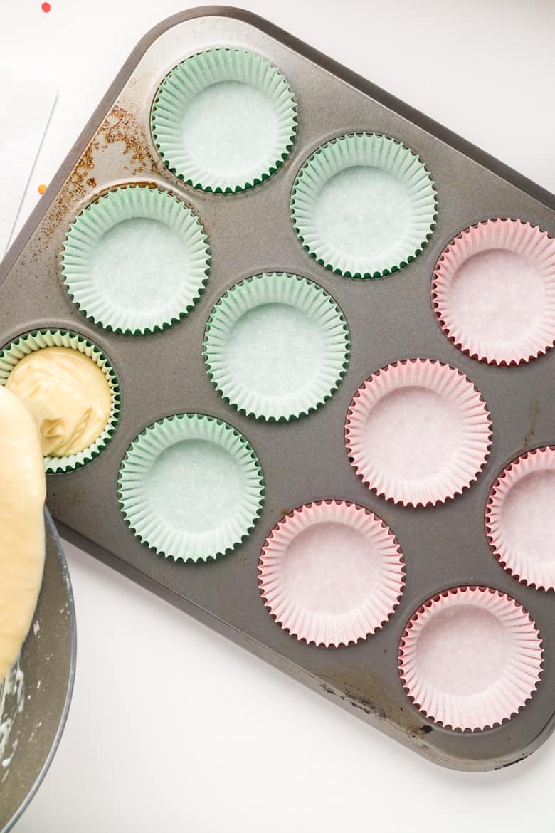 Pouring cupcake batter into lined cupcake tin