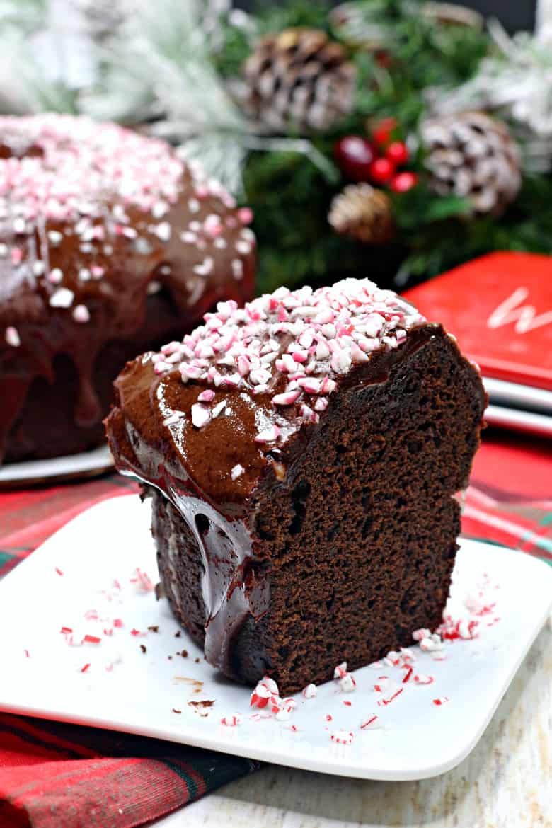 Slice of mocha cake topped with chocolate ganche and crushed peppermints