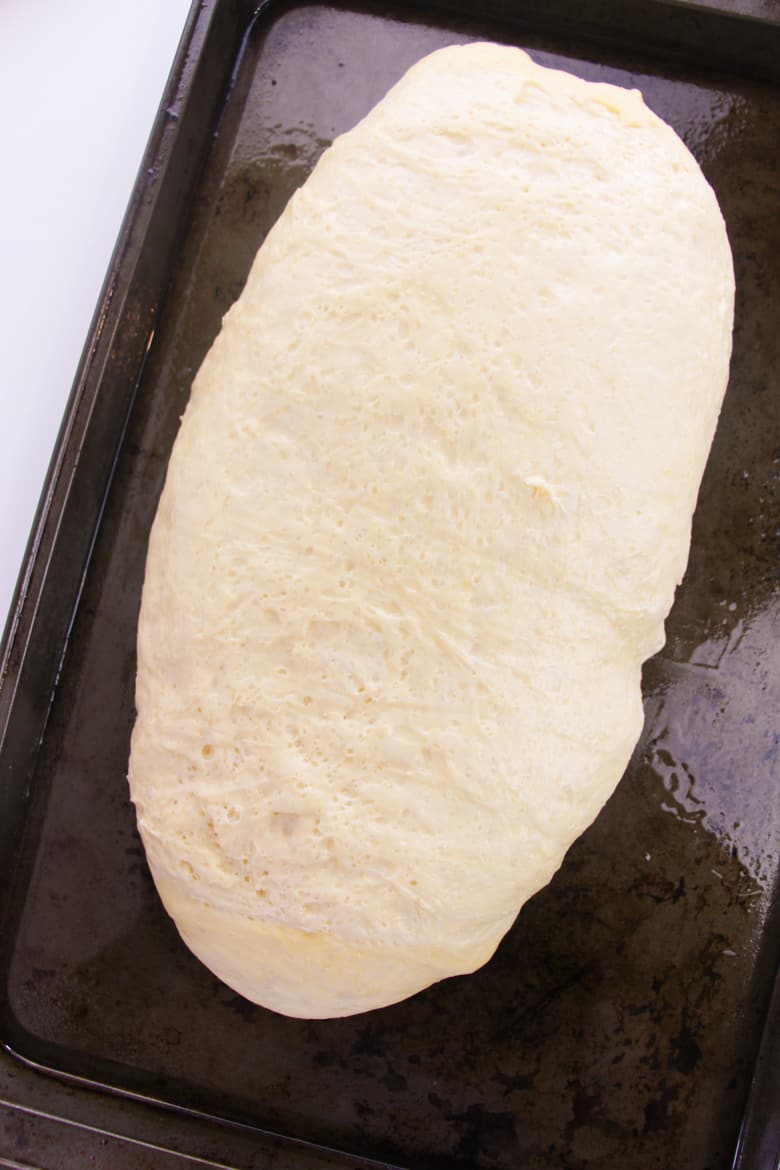 Risen bread dough on baking sheet