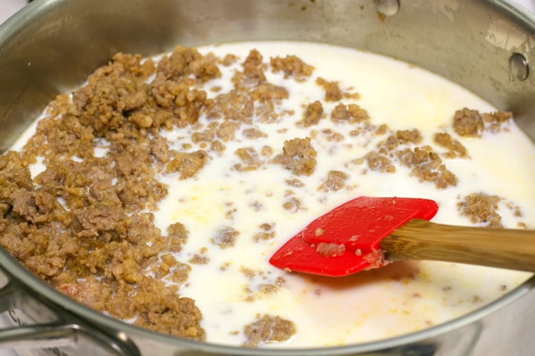 Skillet of cooked ground meat with milk and spatula