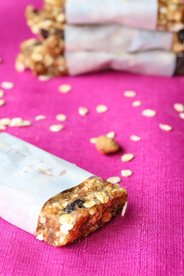 cherry oatmeal bar on pink tablecloth with old-fashioned oats sprinkled on the table