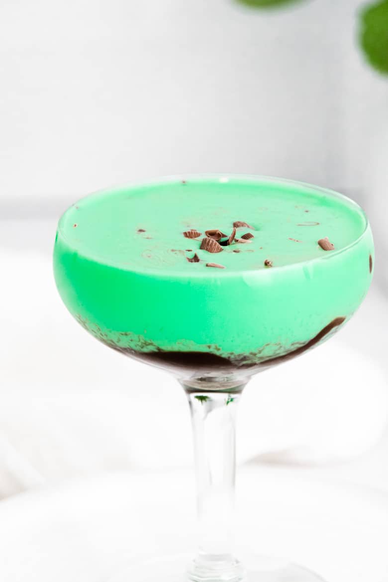 Green drink topped with chocoalte shavings in cocktail glass