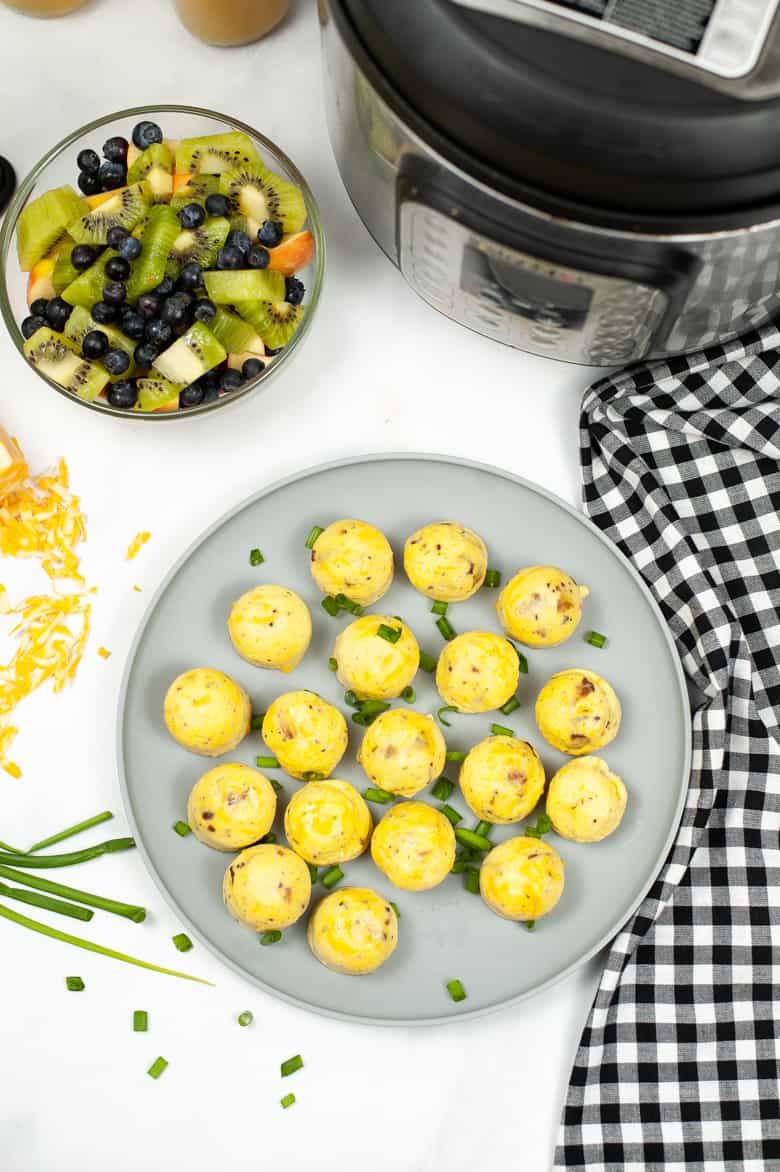 Copycat Starbucks Egg Bites on a grey plate with Instant Pot and fruit salad next to it