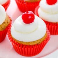 Root Beer Cupcakes topped with buttercream and maraschino cherries