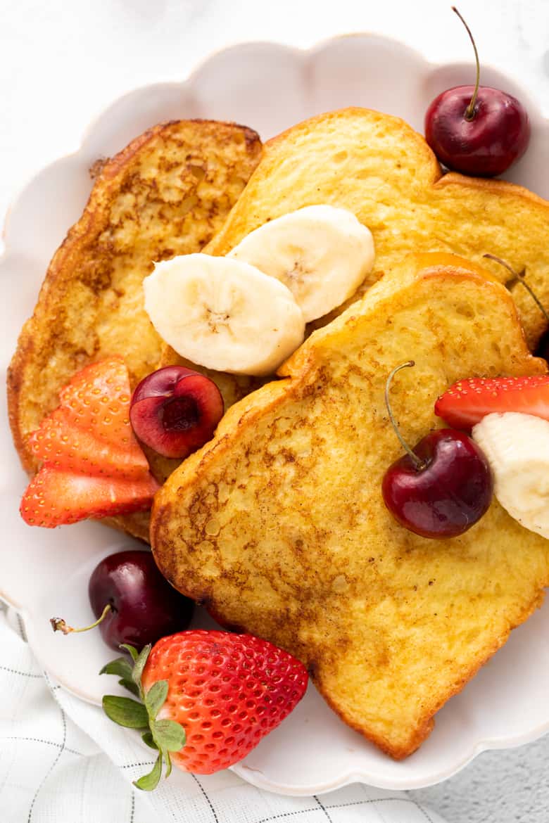 Overhead image of 3 slices of french toast topped with banana slices and berries