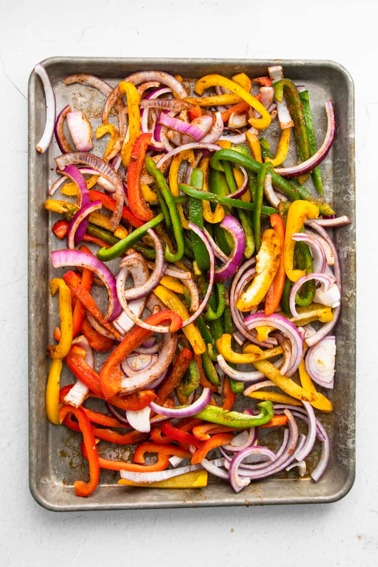 Peppers and onions spread out on sheet pan