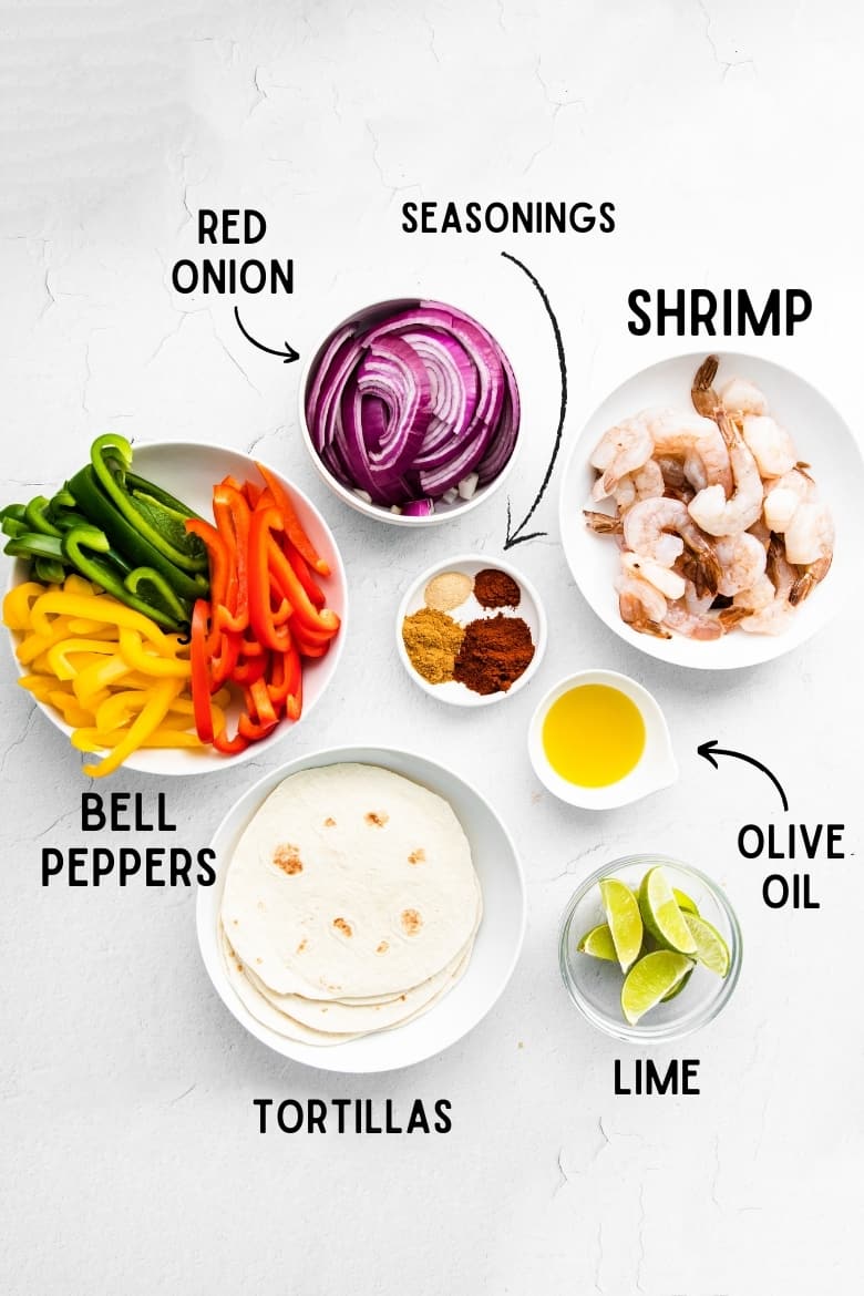sliced red onion, seasonings, raw shrimp, lime cut into wedges, olive oil, tortillas, green, orange, and yellow sliced bell peppers