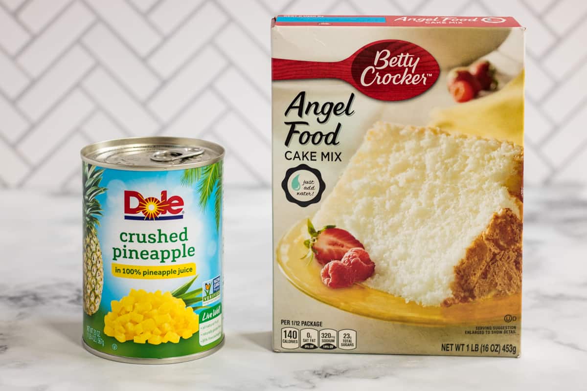 Can of Dole crushed pineapple and box of Betty Crocker angel food cake mix on countertop.