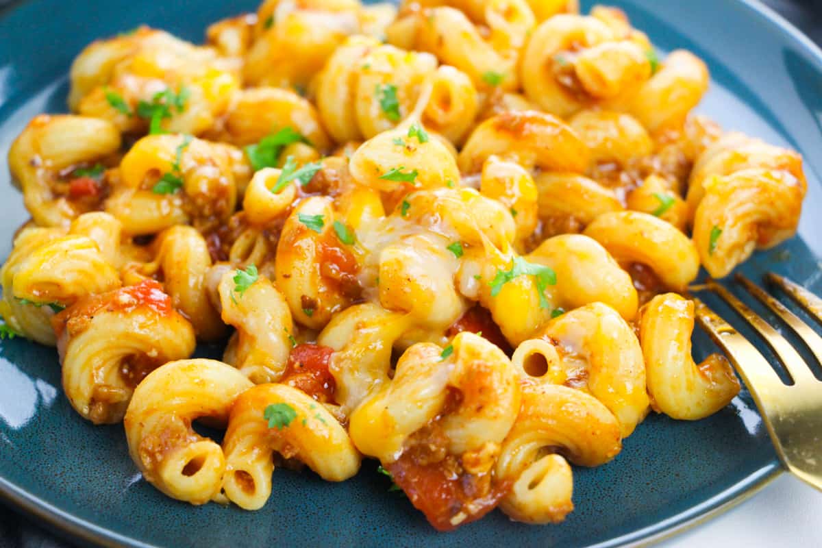 cavatappi pasta with ground beef, red sauce, melted cheese, and fresh cilantro