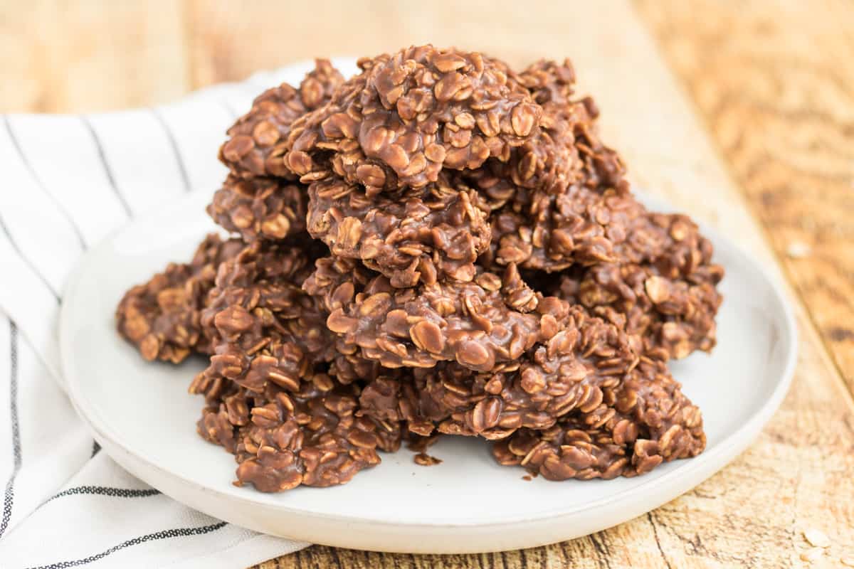 thick chocolate oat cookies piled high on a white plate