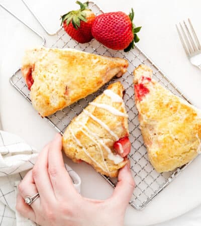 Woman's hand reaching to take a homemade strawberry scone