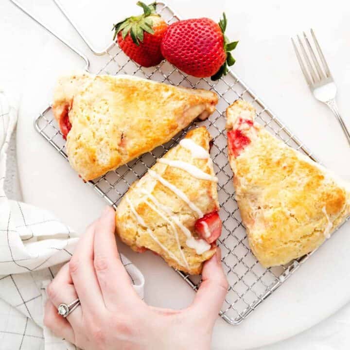 Woman's hand reaching to take a homemade strawberry scone