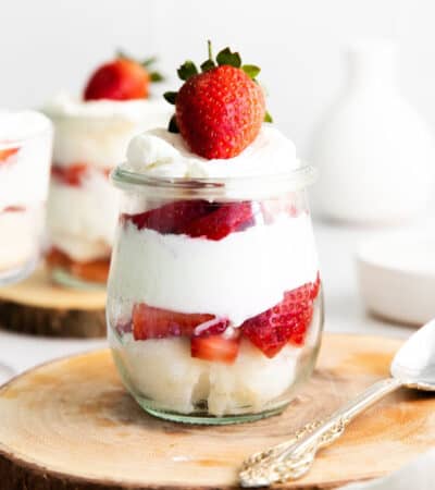 strawberry, angel food cake, and whipped cream trifle in small glass jar