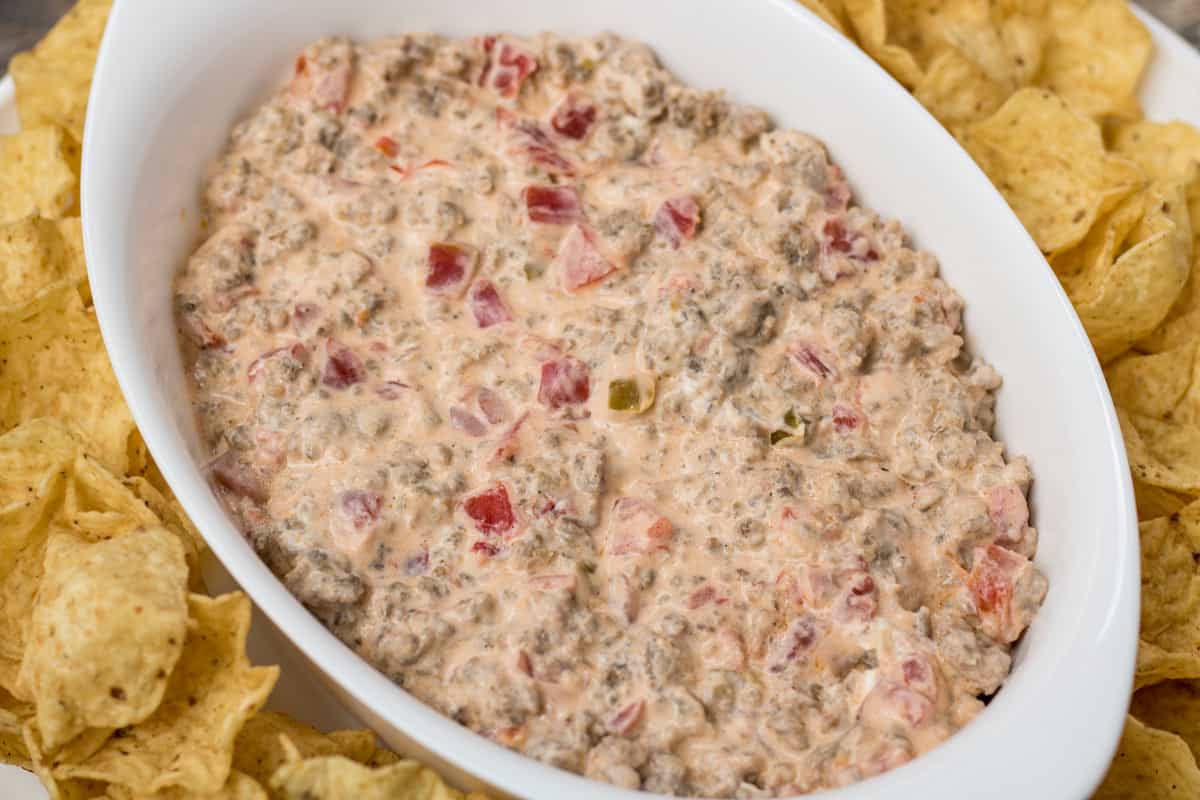 creamy sausage dip in white dish surrounded by tortilla chips