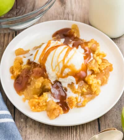 Apple dump cake topped with vanilla ice cream and caramel sauce.