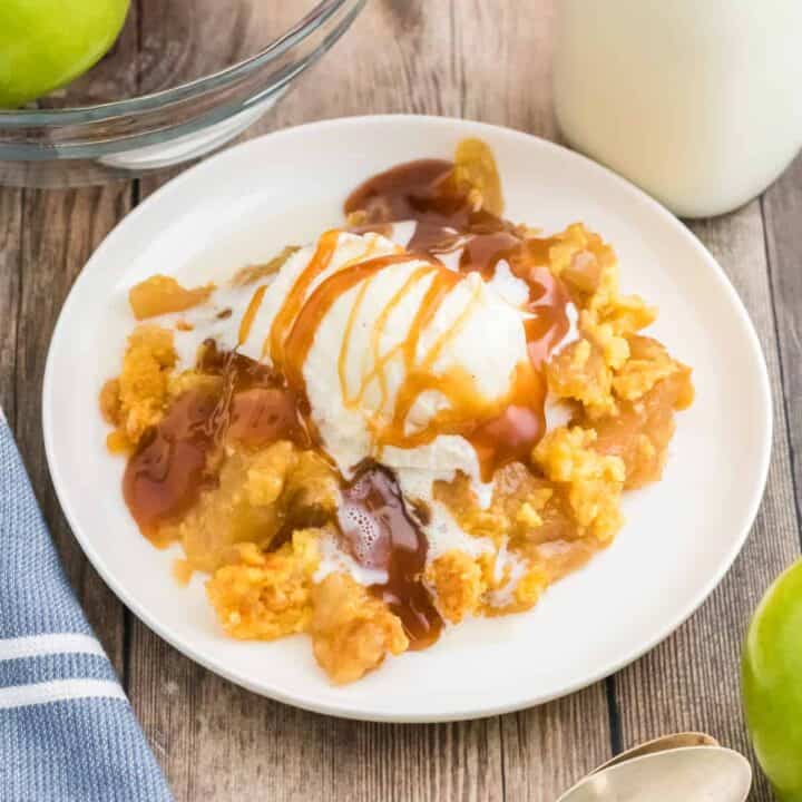 Apple dump cake topped with vanilla ice cream and caramel sauce.