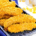 Cornflake chicken tenders on black plate