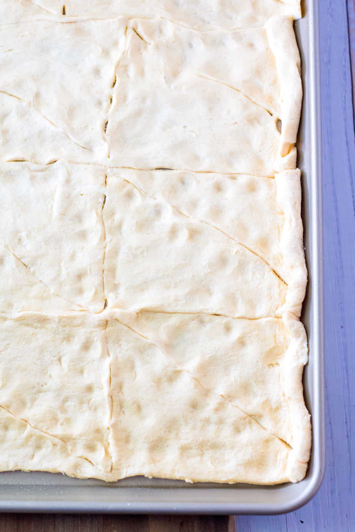 canned crescent roll dough rolled out on sheet pan