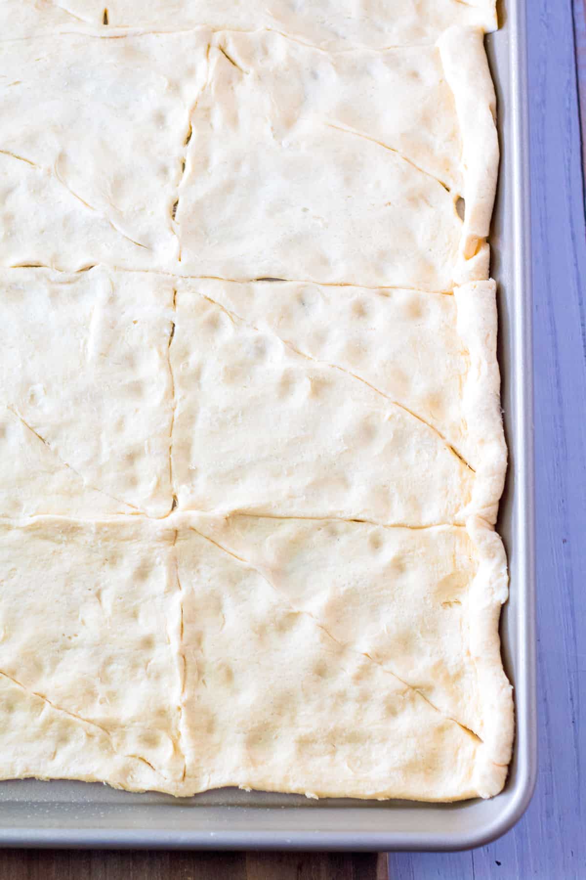 Canned crescent roll dough rolled out on sheet pan.