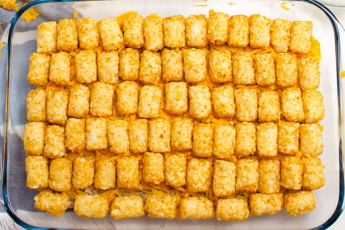 tater tot casserole before baking, with tater tots in even rows on top
