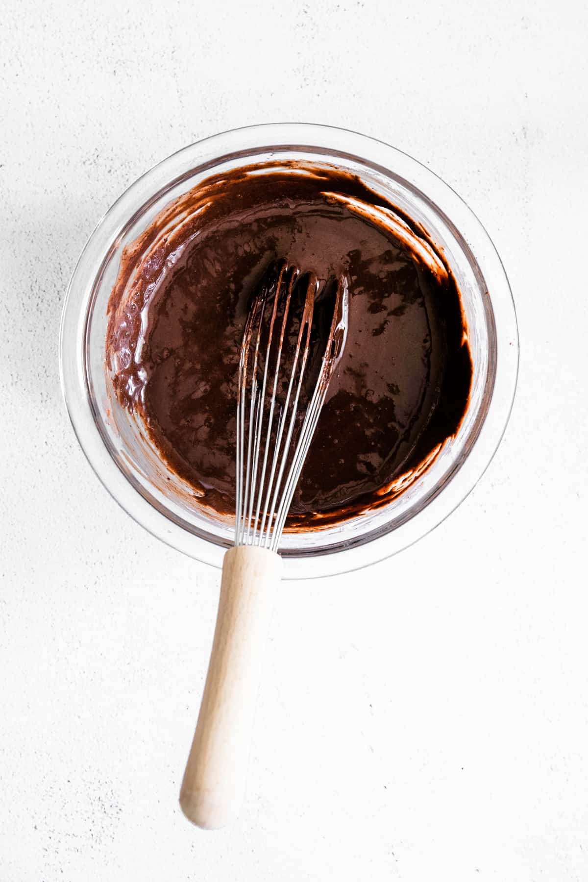 melted chocolate in glass bowl with wire whisk