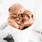 Chocolate ice cream scooped into a white waffle-cone shaped bowl