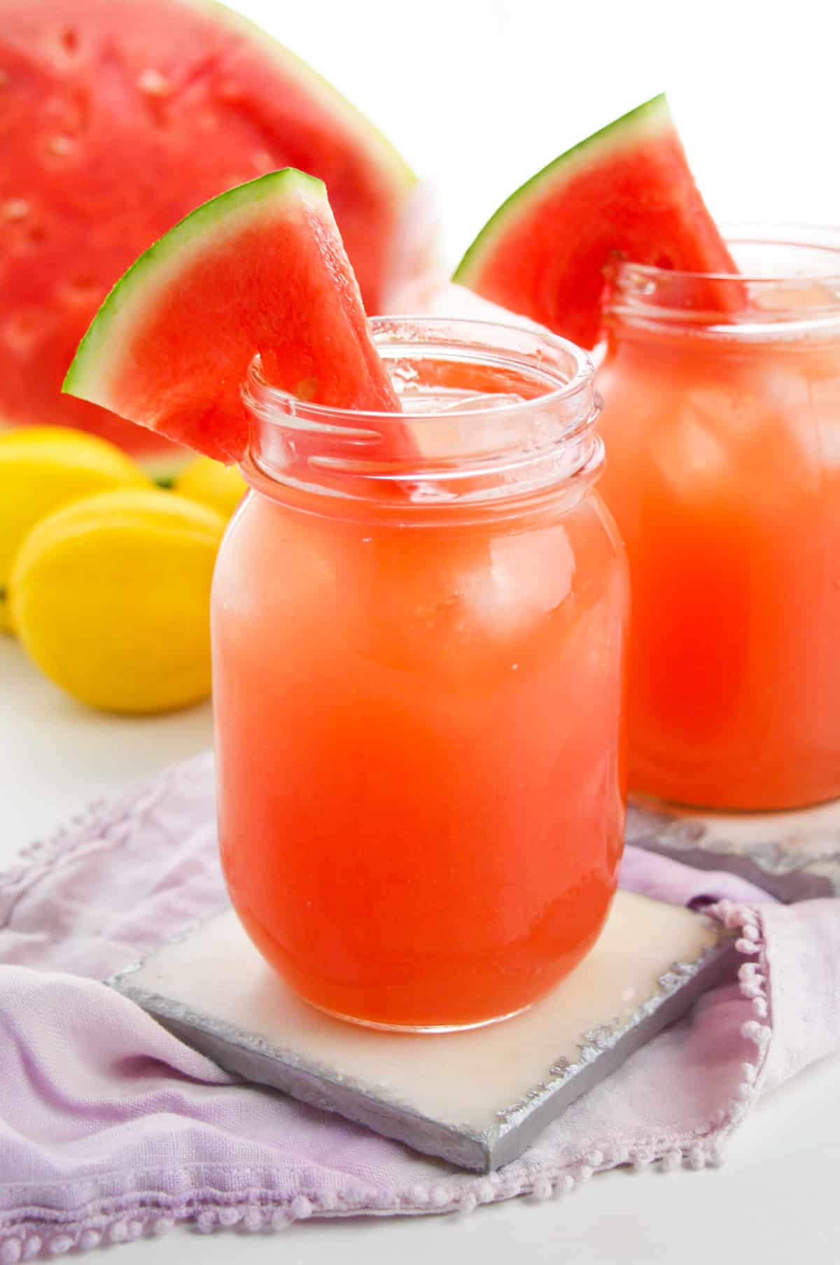 Watermelon lemonade in mason jar garnished with wedge of fresh watermelon. 